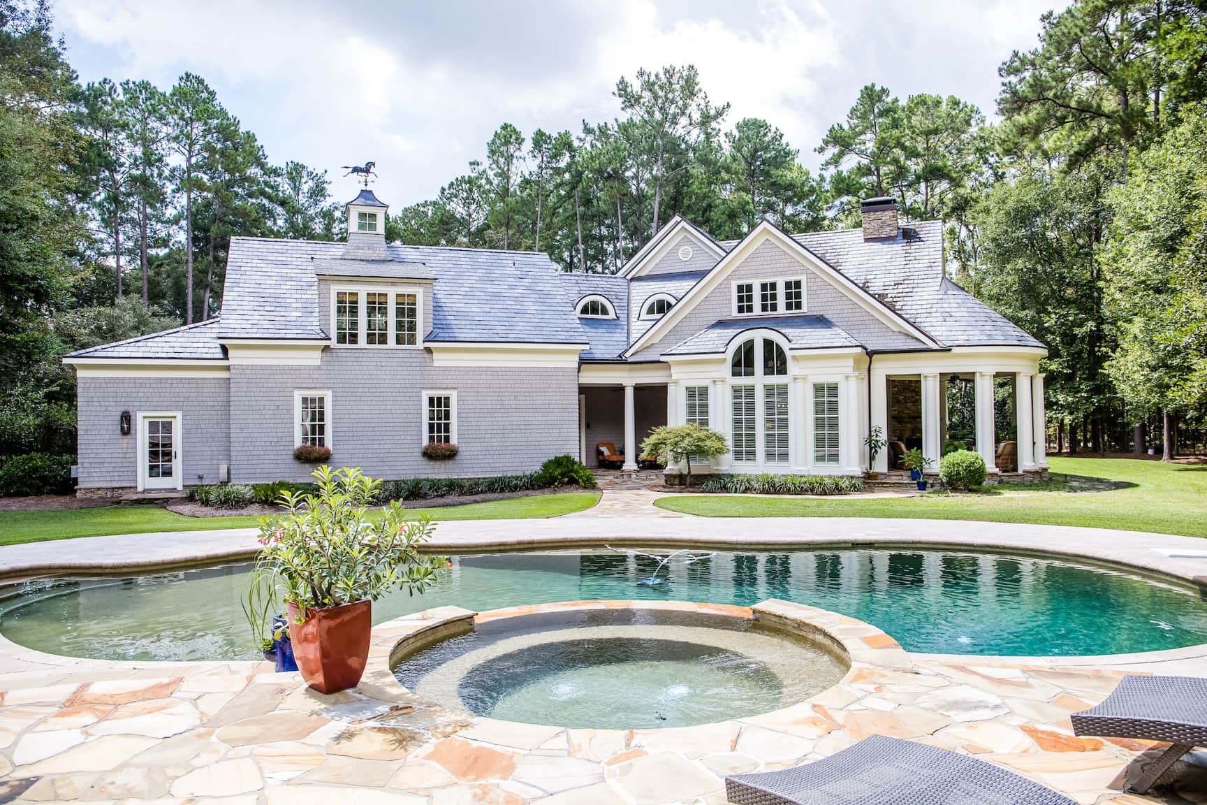 pool renovation with color changing LED lighting that includes water features such as rain curtains and a spa spillway; as well as fire trough feature