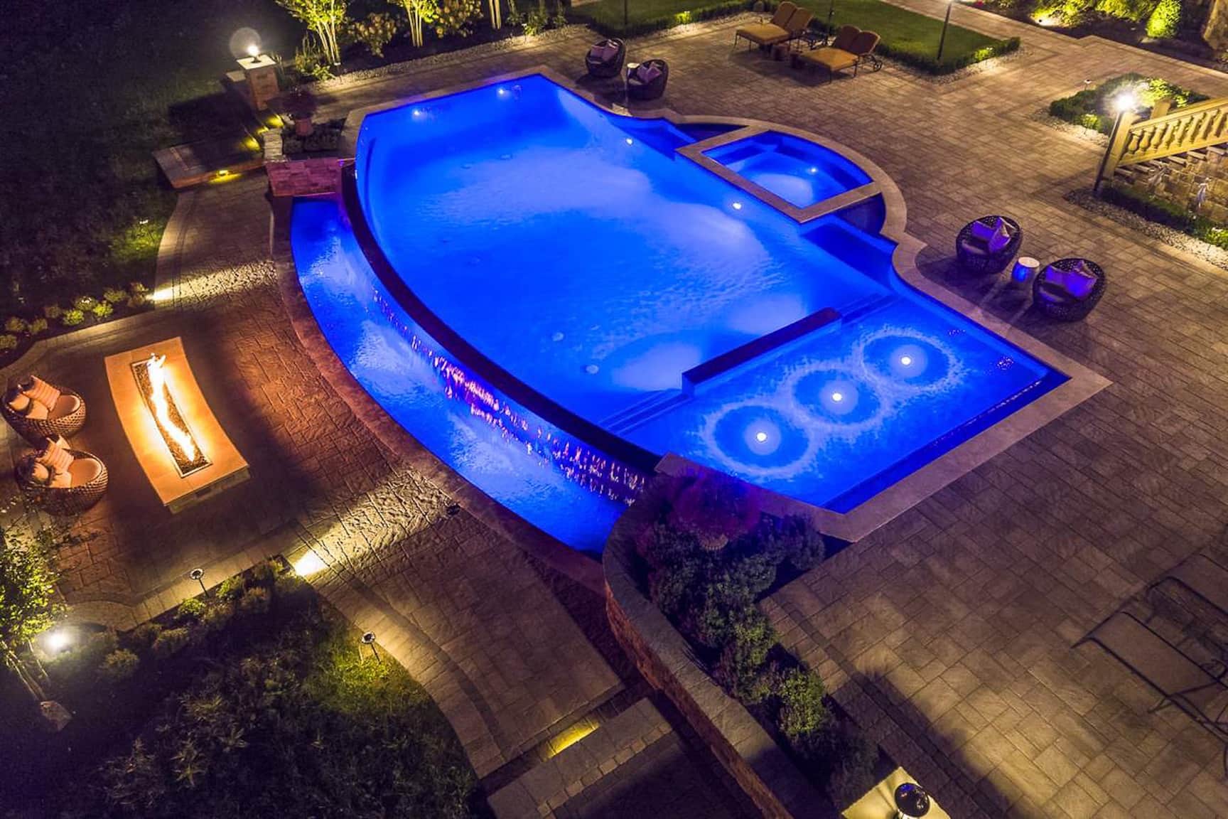 pool renovation with color changing LED lighting that includes water features such as rain curtains and a spa spillway; as well as fire trough feature