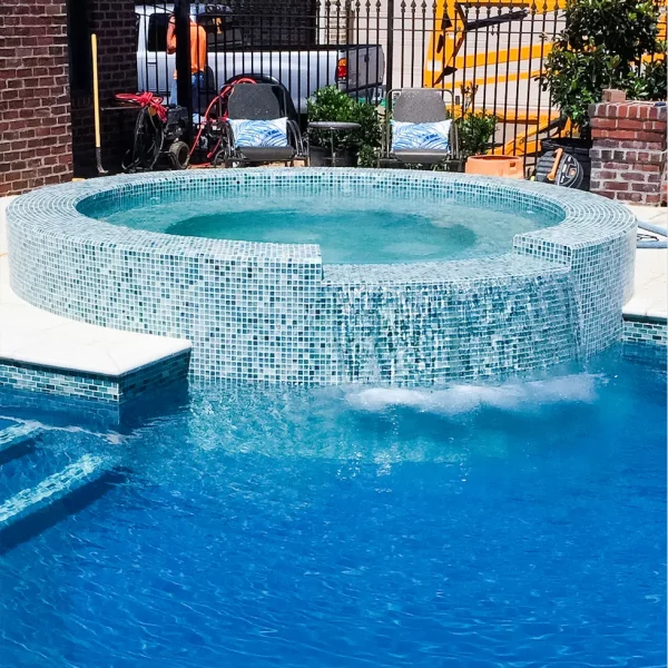 decorative tile and gunite hot tub with a spa spillway attached to the custom gunite swimming pool by Ogden Pools in Memphis, TN