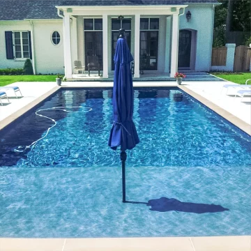 custom swimming pool with sun shelf that includes a built in umbrella feature from Ogden Pools in Memphis